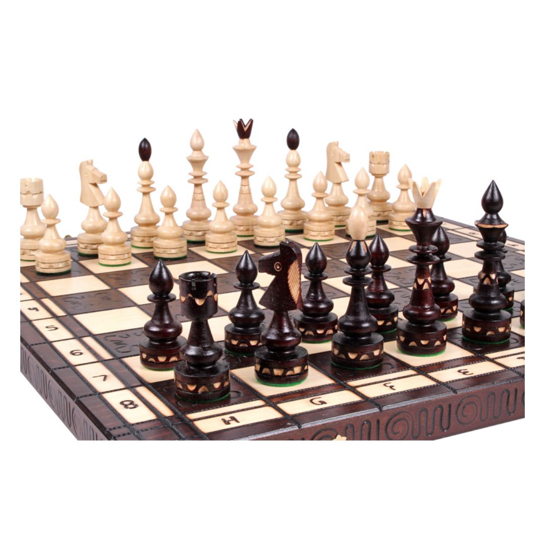 Schackspel i handskuren trä med vackra schackpjäser i trä sett från h8-fältet.