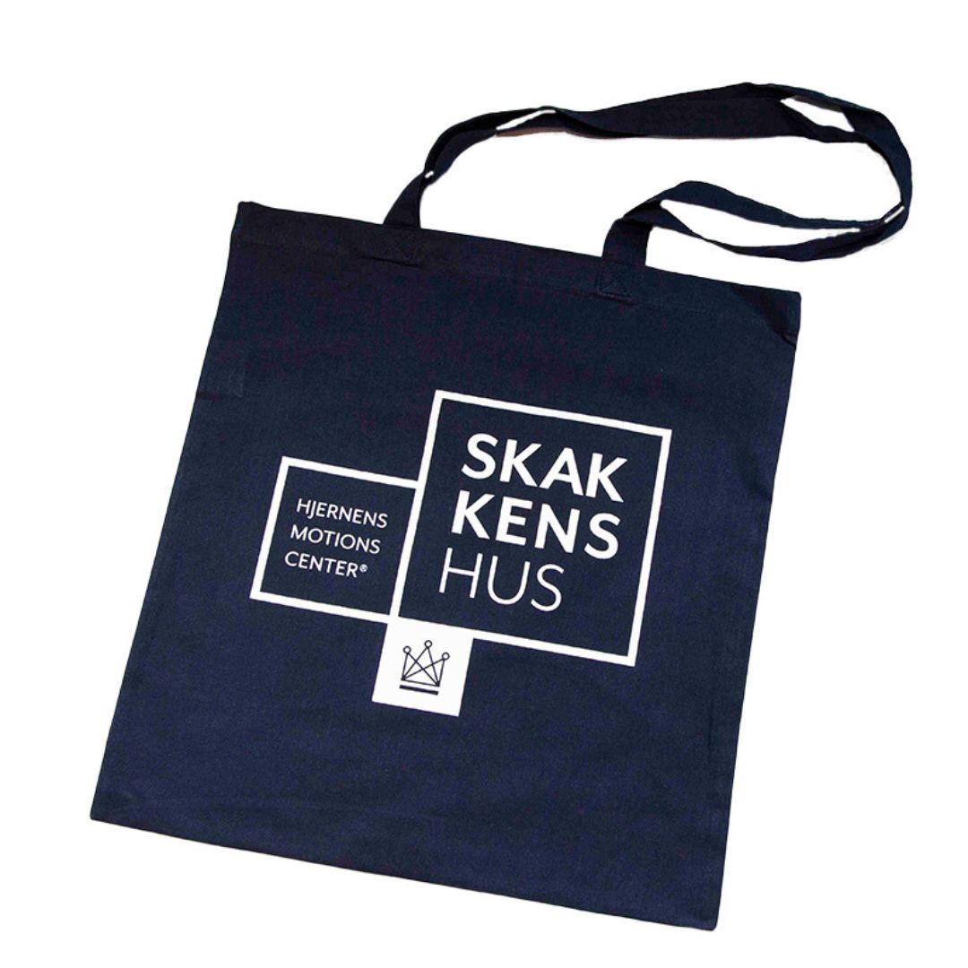 Mulepose i en mörkblå färg med Skakkens hus – hjärnans motionscenter och Dansk Skoleskaks logotyp tryckt på.
