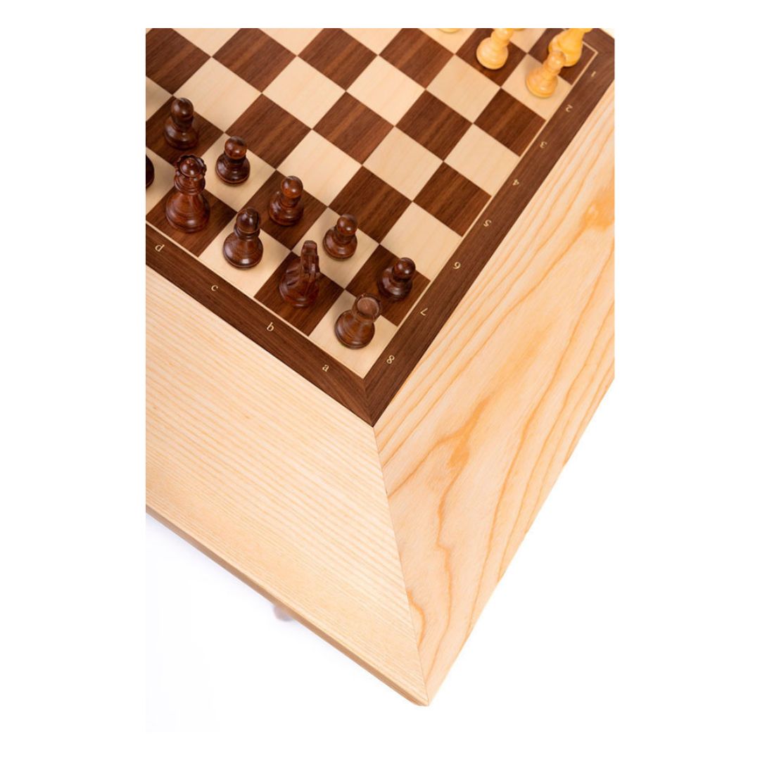 Hörnet av ett schackbord i trä med vackra kanter och ett schackbräde med pjäser i mitten