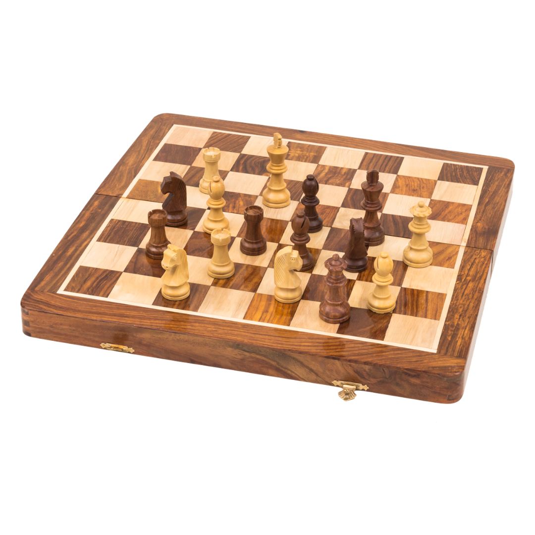 Vikbart schackspel i trä med pjäser som står utspridda i mitten av brädet