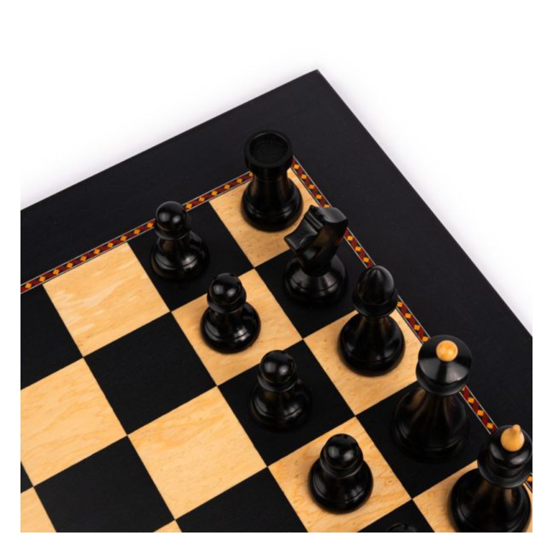 Fokus på hörnet av schackspelet där vi kan se fältet a8 där den svarta tornet står omgiven av sina andra schackpjäser.