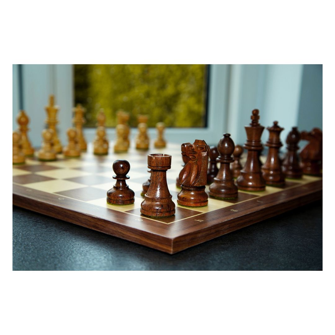 Den mörka schackpjäsen står i centrum tillsammans med de andra schackpjäserna i ett handgjort schackspel från Indien