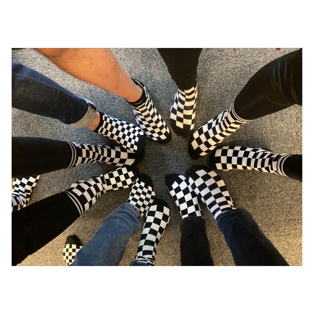 11 fötter klädda med rutiga strumpor i flera storlekar