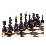 Mörka schackpjäser i trä som hör till hövdingeschackspelet, som kan köpas på schackshoppen.se