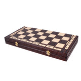 Schackspel sammenklappat med guldbelagda gångjärn på vit bakgrund.