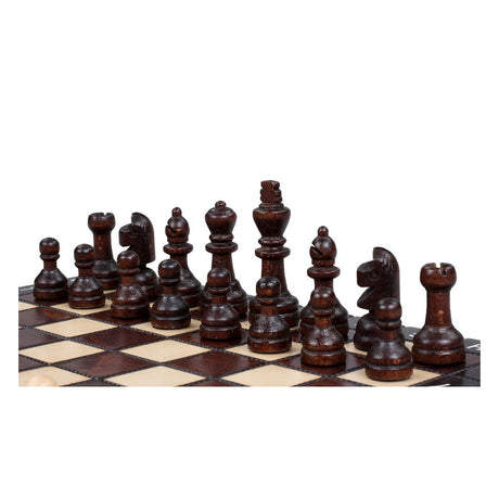 Mörka schackpjäser, handgjorda i trä, tillhörande ett litet hopfällbart handskuret schackspel.