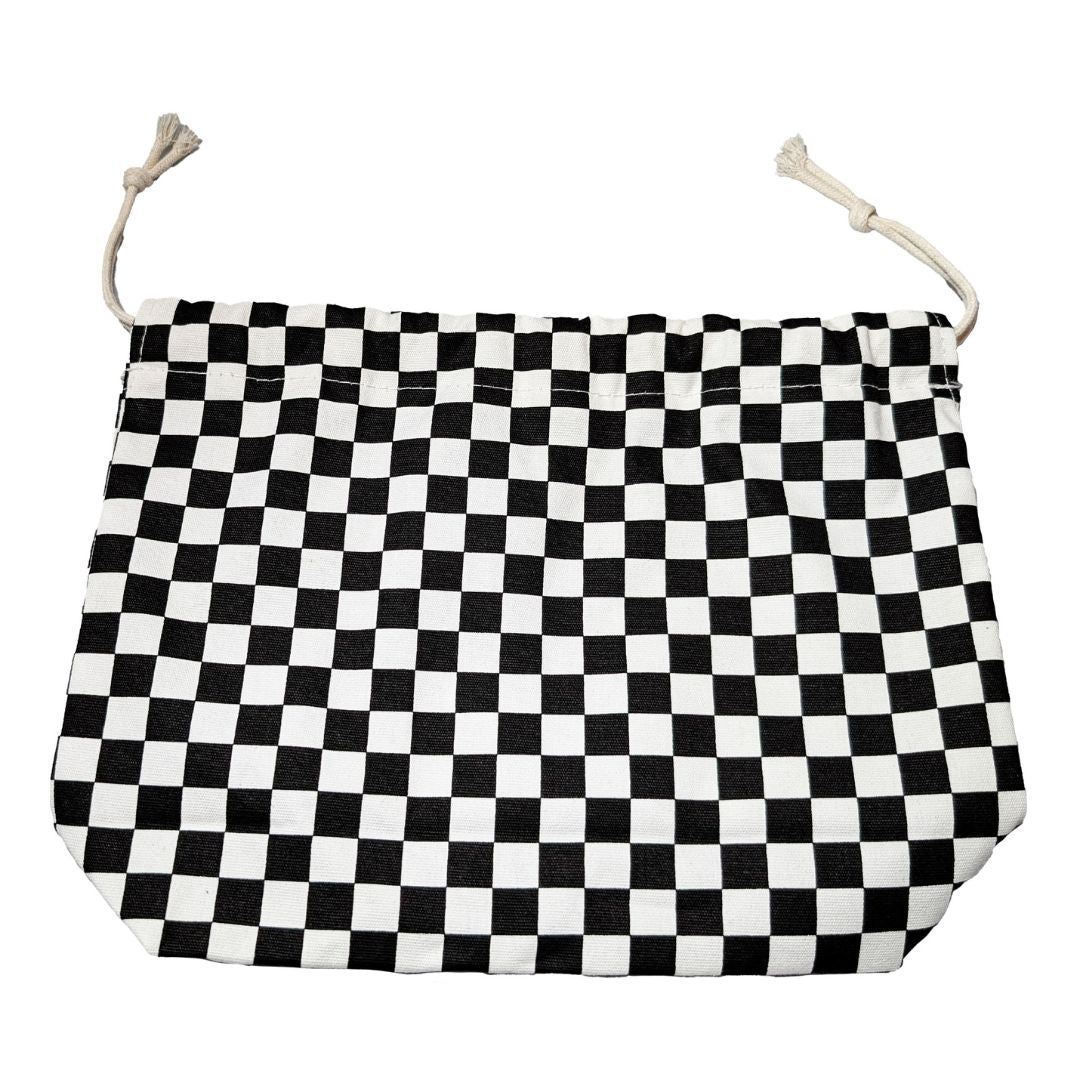 Pjäspåse med schacktema som ligger platt utvikt på en vit bakgrund med bomullssnören uppe i luften