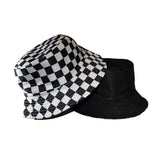 Två olika kepsar. Den ena med rutmönster, som vilar på en svart keps med rutmönster på insidan.