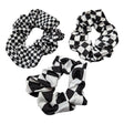 Tre scrunchies med schacktema med liten, mellan och stora schackrutor. Köp mer, spara mer