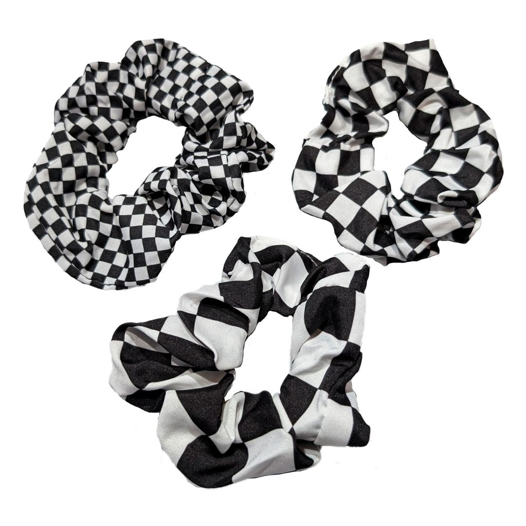 Tre scrunchies med schacktema med liten, mellan och stora schackrutor. Köp mer, spara mer