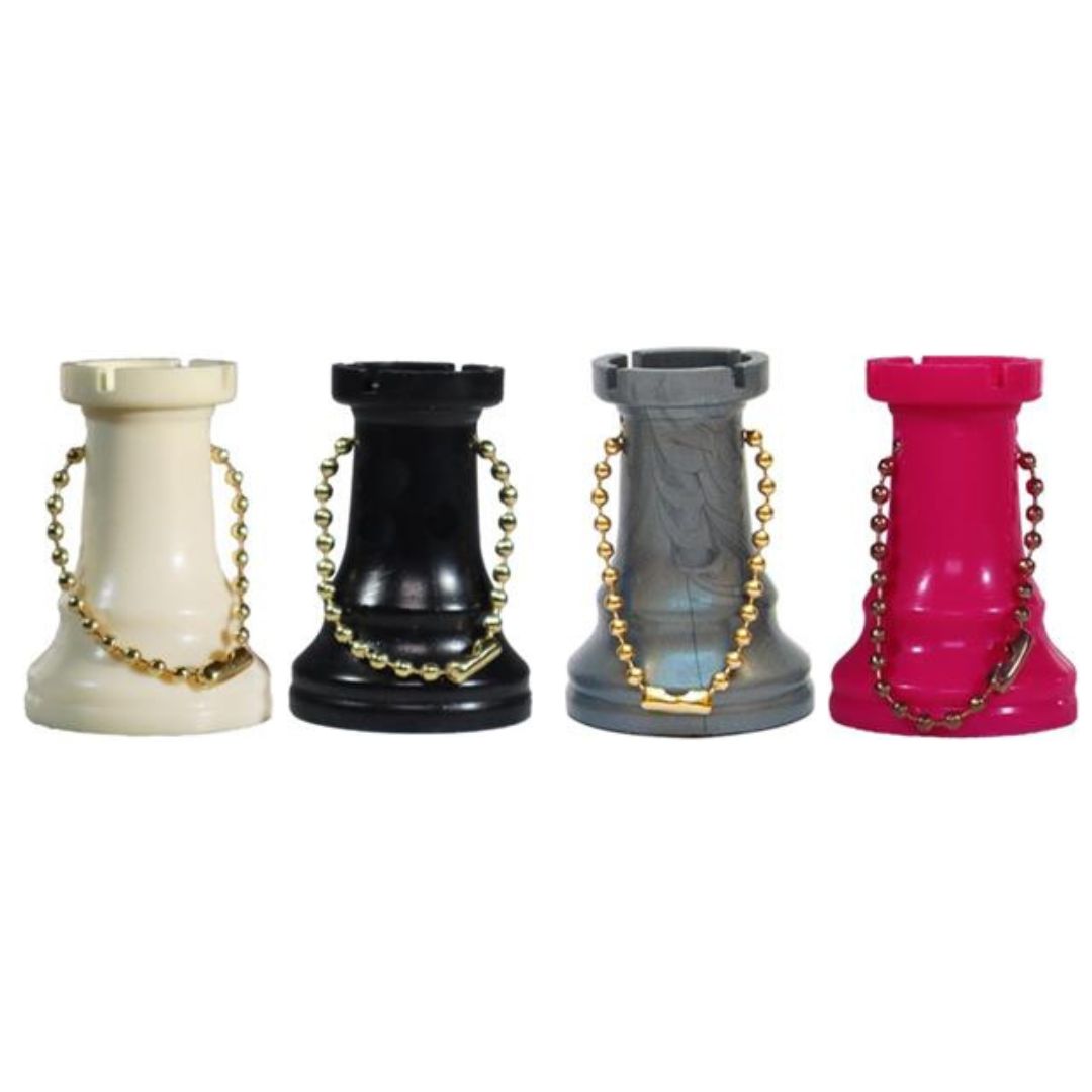 Fyra schackpjäser med torn i form av nyckelringar i fyra färger - vitt, svart, silver och rosa - på vit bakgrund
