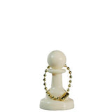 Schackpjäsen som nyckelring med en liten spik genom schackpjäsens topp