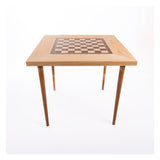 Ett stort, brunt och vackert schackbord i ask med ett schackbräde i valnöt placerat i mitten