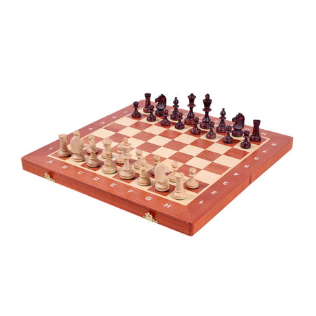 Schackspel i mahogny som kan fällas ihop men är guldbelagt och har pjäserna stående på sina startplatser.