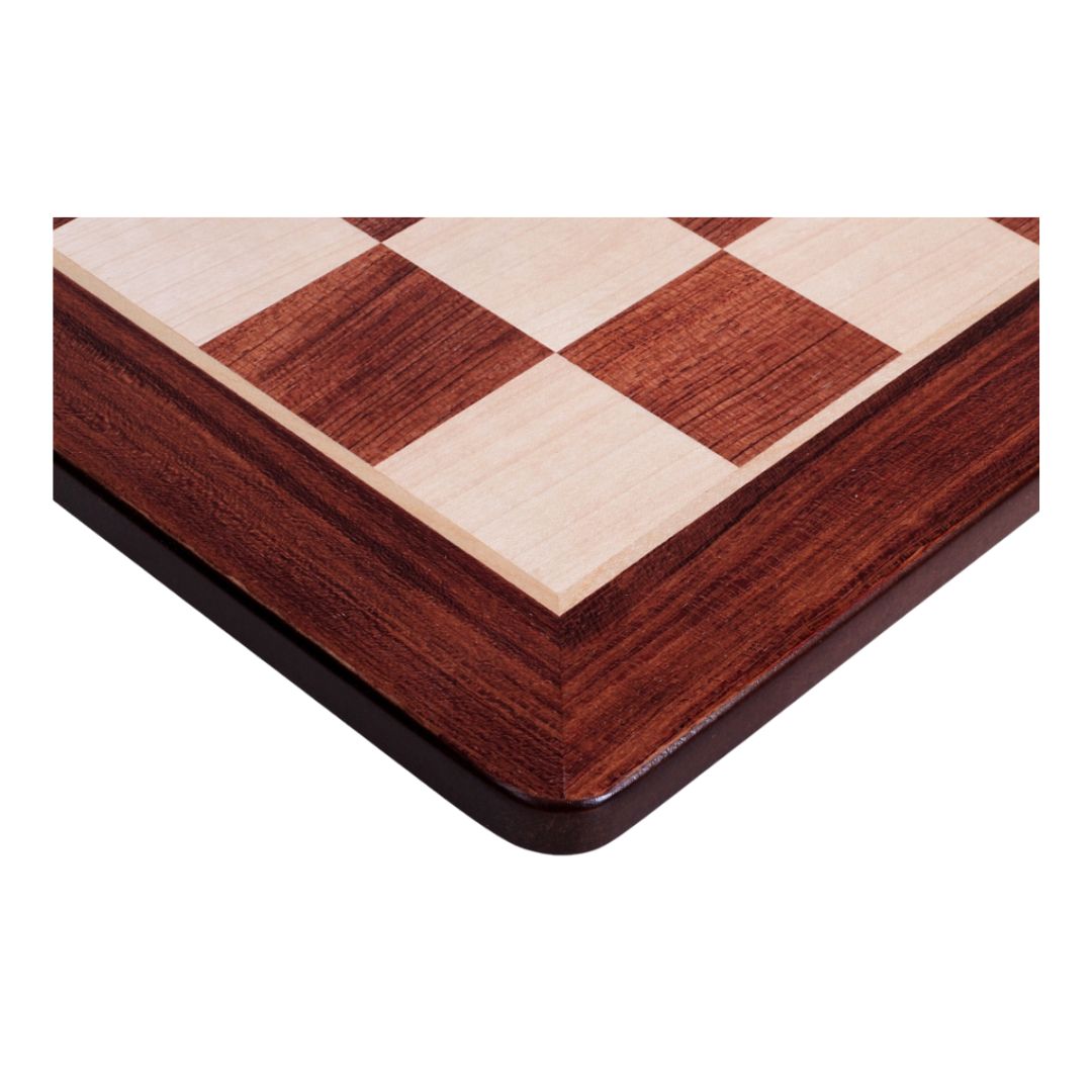 Fokus på hörnet av schackbrädet i padauk och lönn med rundade hörn som är snyggt sammanfogade och har en fin finish vid fogarna.