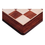 Fokus på hörnet av schackbrädet i padauk och lönn med rundade hörn som är snyggt sammanfogade och har en fin finish vid fogarna.