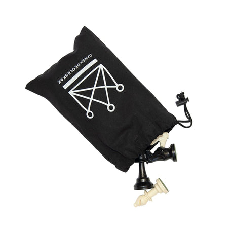 Svart schackpjäspåse med plats för schackpjäser och med Dansk Skoleskak-logotypen tryckt öppen med svarta och vita schackpjäser som kommer ut ur den