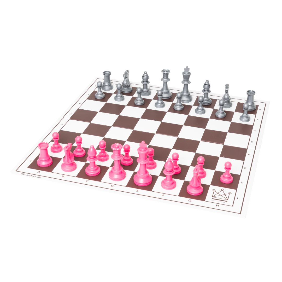 Schackspel med silverfärgade och rosa schackpjäser placerade på sina startrutor