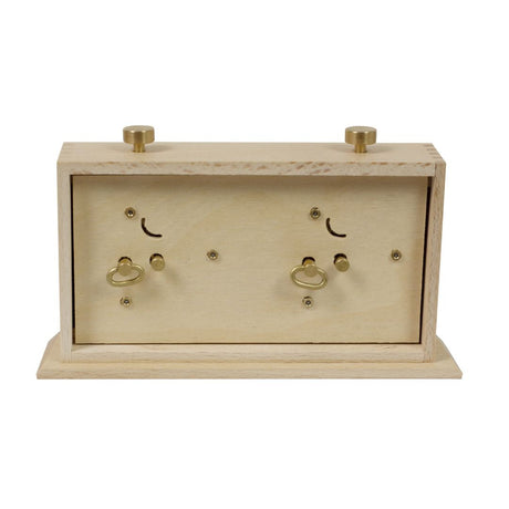 På baksidan av den stora analoga schackklockan kan man dra upp den så att tiden är exakt.