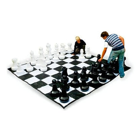 Två unga människor spelar schack på ett stort schackbräde