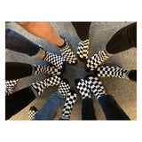 11 fötter klädda med rutiga strumpor i flera storlekar